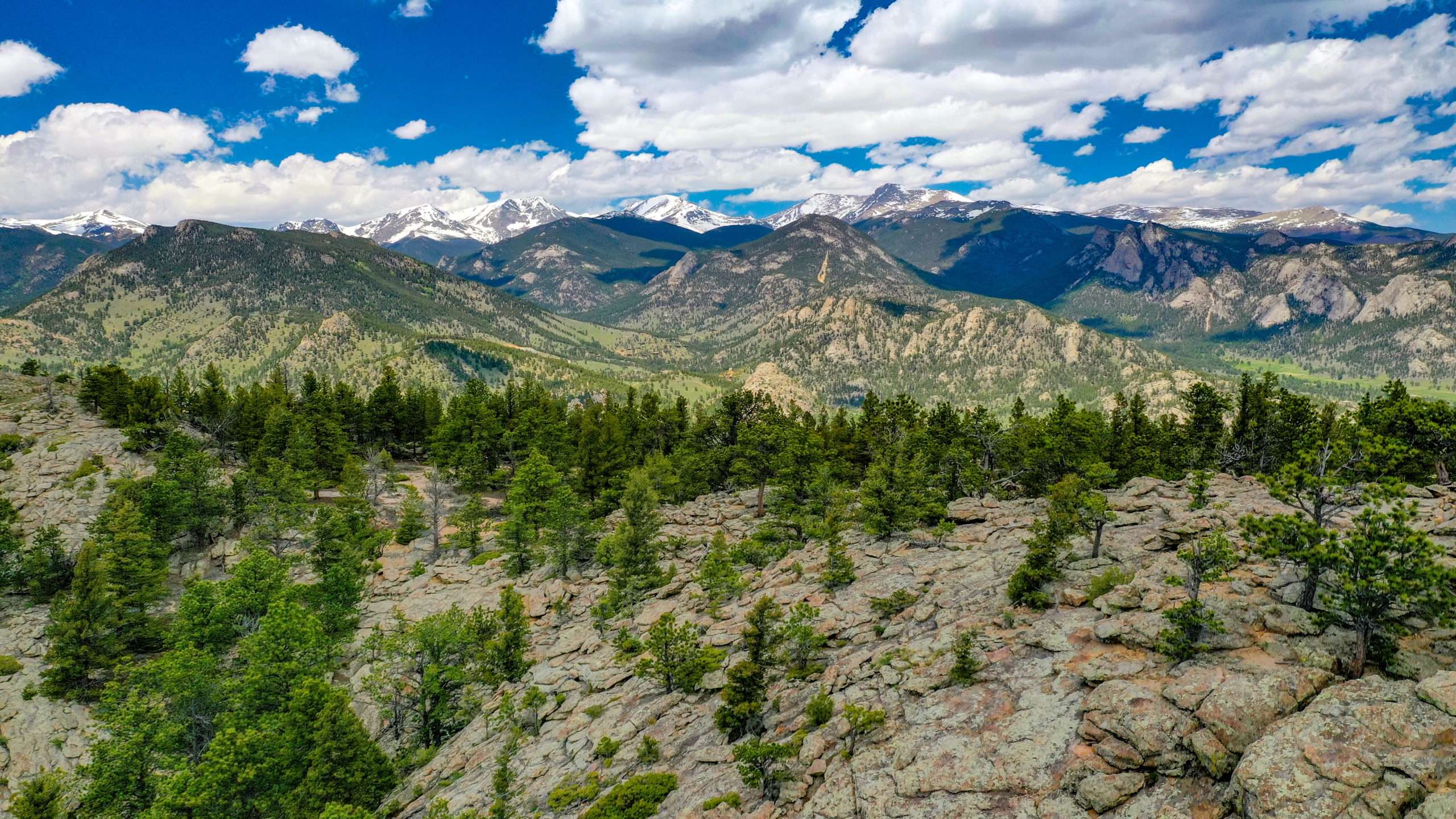 This is an aerial image pointed northwest from Prospect Mountain though Rocky Mountain National Park and Beavers Meadows to the Mummy Range with Chiquita, Chapin, Ypsilon and Fairchild Mountains shedding winter snowpack.